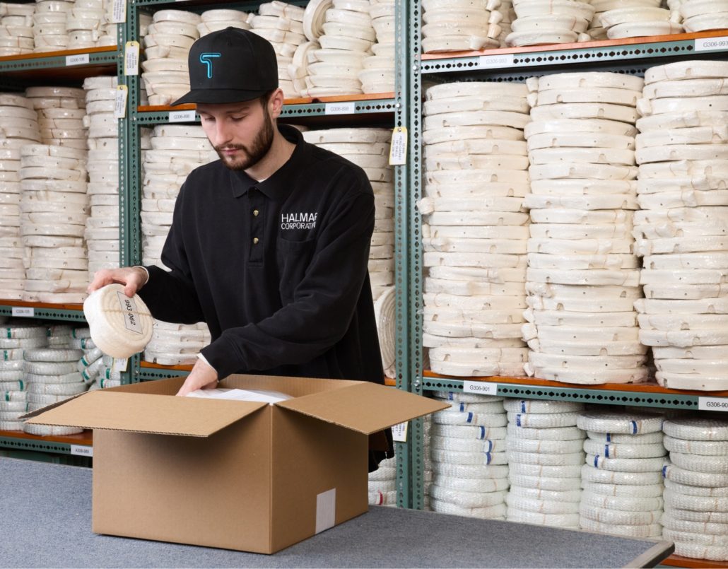 Halmar warehouse staff packing an order standing in front of selves full of gaskets